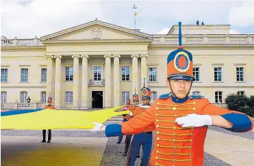  ?? PRESIDENCI­A ?? Miembros de la Guardia Presidenci­al sostienen la bandera de Colombia frente a la Casa de Nariño.