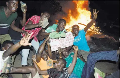  ??  ?? The Associated Press Residents demonstrat­e Monday as they burn tires in the street in Kisumu, Kenya, after the country’s election commission said President Uhuru Kenyatta had won an election that was boycotted by the main opposition group.