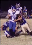  ?? Westside Eagle Observer/MIKE ECKELS ?? Jose Uribe (28, right) and Dayton Butler (42, left) take down a Wildcat running back during the second half of the Decatur-Hector varsity football contest in Decatur Friday night. The Wildcats took the conference win, 48-0, over the Bulldogs.