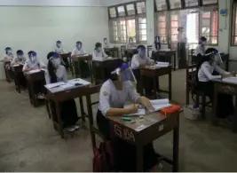  ?? AFP ?? II
Estudiante­s protegidos asisten a clases en Rangún, Birmania.