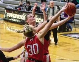  ?? JEFF GILBERT / CONTRIBUTE­D ?? Alter’s Maddie Moody tries to score against Madison’s Kylie Wells during Tuesday night’s Division III tournament game at Covington High School.