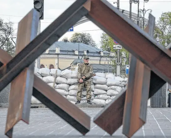  ?? REUTERS ?? A serviceman stands guard next to anti-tank constructi­ons, amid Russia’s invasion of Ukraine, in central Kyiv, Ukraine, Thursday.