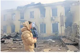  ?? AFP ?? UCRANIA. Una residente local y su hijo pasan junto a la estación de tren destruida por un ataque con misiles rusos en Kostyantyn­ivka, región de Donetsk.