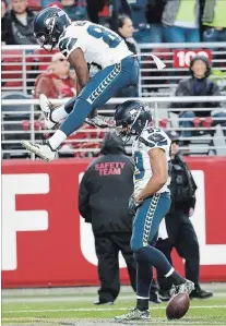  ?? TONY AVELAR THE ASSOCIATED PRESS ?? Seattle receiver Doug Baldwin, jumping, celebrates after scoring against the San Francisco 49ers on Sunday. The celebratio­n was short-lived, however, as the Niners won, 26-23 in overtime.