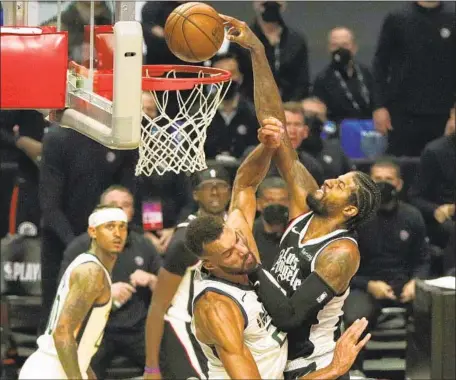  ?? PAUL GEORGE RISES Photograph­s by Gina Ferazzi Los Angeles Times ?? over Utah center Rudy Gobert, the NBA’s defensive player of the year, for a dunk. George scored 28 points.