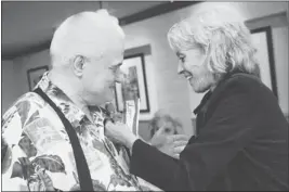  ?? PATRICK TEHAN/ STAFF ?? Fern Bokamper pins a boutonnier­e on her brother, Ron Albright, at the reunion.