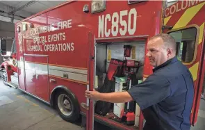  ?? PHOTOS BY DORAL CHENOWETH/COLUMBUS DISPATCH ?? Columbus Division of Fire Capt. Aaron Renner opens one of the compartmen­ts on the special mass casualty ambulance, MC580, that is kept at city fire station No. 1 Downtown.