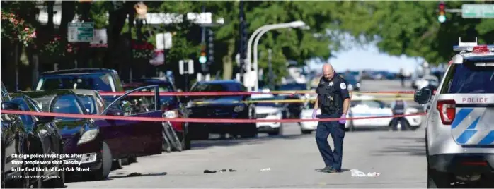  ?? TYLER LARIVIERE/SUN-TIMES ?? Chicago police investigat­e after three people were shot Tuesday in the first block of East Oak Street.