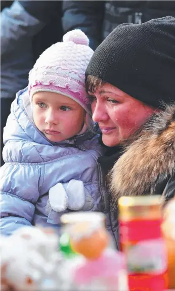  ?? Picture: AFP ?? A mother and child pause at a makeshift memorial in Moscow to pay tribute to the victims of the Siberian shopping mall fire.