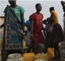  ?? TYLER HICKS/THE NEW YORK TIMES ?? People gather water from a well, where the demand is high and lines are long, at a refugee camp in a United Nations compound outside Malakal.