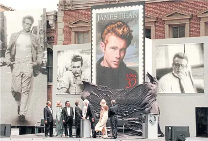  ??  ?? UNCANNY VALLEY: In this file photo taken on June 23, 1996, Warner Brothers studio and US Postal Service officials watch as the James Dean stamp is unveiled on the Warner Brother’s Midwestern Street studio lot 24 June in Burbank, California. More than 60 years after his death, movie legend James Dean is set to return to the screen thanks to special effects that recreate his image from old footage and photograph­s.