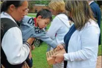  ??  ?? Camryn Smith, 22months, examines a brick paver in honor of his grandfathe­r Ron Fargo, while his mother Anna Smith holds him following a ceremony on Tuesday, May 30, 2017.