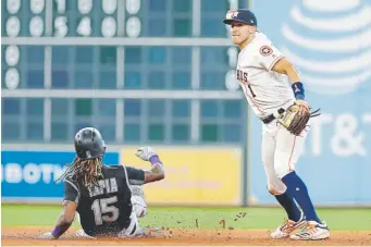  ?? Michael Wyke, The Associated Press ?? Houston Astros shortstop Carlos Correa turns a double play over Rockies left fielder Raimel Tapia during the seventh inning of Wednesday’s game at Minute Maid Park.