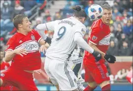  ?? Kamil Krzaczynsk­i AFP/Getty Images ?? ZLATAN IBRAHIMOVI­C heads home the game’s only goal against the Fire’s Grant Lillard, left, and Bastian Schweinste­iger in first-half stoppage time.