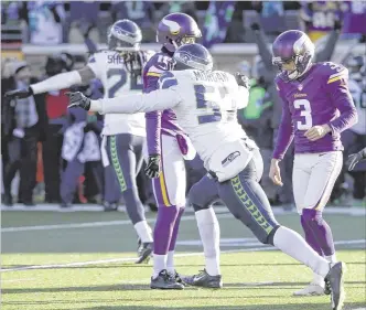  ?? JIM MONE / ASSOCIATED PRESS ?? Seahawks players Richard Sherman and Mike Morgan react after Vikings kicker Blair Walsh (right) hooked a 27-yard fifield- goal attempt wide left at the end of Sunday’s game.