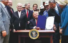  ?? —AP ?? VIRGINIA: In this file photo, Sen. Shelley Moore Capito, R-W. Virginia, right, Sen. Joe Manchin, D-W. Virginia, second from right, and coal miners, watch as President Donald Trump holds up H.J. Res.