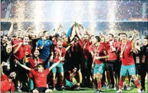  ?? DANIEL BELOUMOU OLOMO/AFP AFP ?? The Morocco team celebrate after winning the African Nations Championsh­ip (CHAN) final football match between Morocco and Mali at Stade Ahmadou Ahidjo in Yaounde, Cameroon, on Sunday.