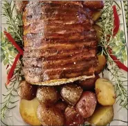  ?? ?? Made with a recipe requiring few ingredient­s, this boneless pork loin was wrapped in bacon and roasted with red or Baby Dutch Yellow potatoes.