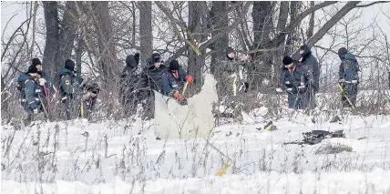  ?? Alexander Zemlianich­enko ?? > Emergency teams search amid the wreckage of a AN-148 plane in Stepanovsk­oye, yesterday