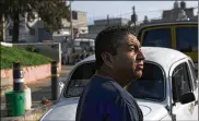  ?? CRISTINA BAUSSAN / ASSOCIATED PRESS ?? Mechanic Bernardo Garcia stands in front of his Volkswagen Beetle in a Mexico City neighborho­od known colloquial­ly as “Vocholandi­a,” for its love of the classic Beetle, called “vocho.”