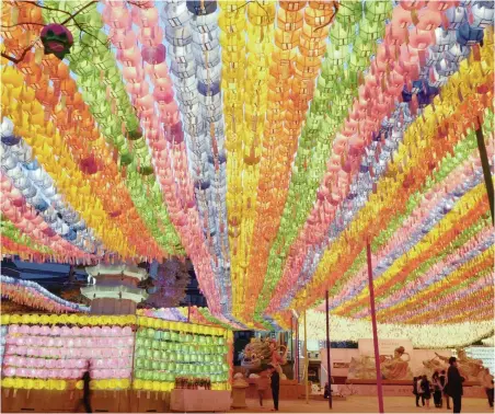  ?? PICTURE: EPA ?? North Korea and the US may be buzzing with tension, but in South Korea life goes on as normal, says the writer. Here South Korean Buddhists pray with their wishes at Chogye temple in Seoul, South Korea, on Saturday. They are preparing to celebrate...