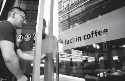  ??  ?? A man walks into a Luckin Coffee store in Beijing. Luckin, which only officially launched in January, has opened more than 660 outlets in 13 Chinese cities, posing a challenge to Starbucks. — Reuters