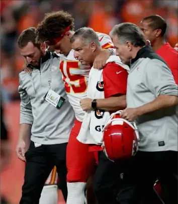  ?? Matthew Stockman/Getty Images ?? Kansas City quarterbac­k Patrick Mahomes is helped from the field Thursday night after injuring his knee in the second quarter against the Broncos in Denver.