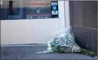  ?? (AP/David Zalubowski) ?? A bouquet of flowers rests Tuesday outside the door of a Broadway tattoo parlor in Denver.