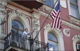  ?? AP PHOTO/DMITRI LOVETSKY ?? A consulate employee lifts up the U.S. flag at the U.S. consulate in St. Petersburg, Russia, on Saturday. The flag was flown at half-mast to mourn victims of Kemerovo fire killing 64 people.