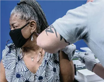  ?? JOSE A IGLESIAS jiglesias@elnuevoher­ald.com ?? Peachie Tresbant receives a shot of the Pfizer-BioNTech COVID-19 vaccine at the Christine E. Lynn Rehabilita­tion Center at Jackson Memorial Hospital in Miami on Jan. 4. A new vaccinatio­n site at MDC North will administer 2,000 doses a day.