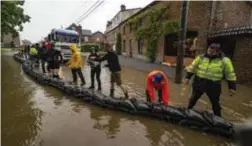  ?? FOTO TOM PALMAERS ?? Brandweer en bewoners probeerden het water op tegen te houden met zandzakjes, maar het bleek een gevecht tegen de bierkaai.