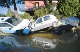  ?? BOBO ANTIC/AP ?? Parked cars pile up on a road Friday following a flood in Pianello di Ostra, Italy. Heavy downpours triggered flash flooding in the central part of the country.