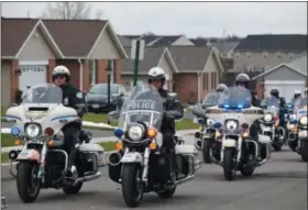  ?? MARIAN DENNIS — DIGITAL FIRST MEDIA ?? A motorcade of area police department­s descending on Fox Lane as they came to visit and deliver a holiday meal to the home of fallen Officer Brad Fox’s family in Gilbertsvi­lle.