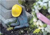  ?? DAVID BEBEE WATERLOO REGION RECORD FILE PHOTO ?? A hard hat and work boots were left with wreaths at the Workers’ Monument in Victoria Park during the National Day of Mourning ceremony in 2019. This year’s event will be online.