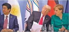  ?? STEPHEN CROWLEY/THE NEW YORK TIMES ?? President Donald Trump speaks with German Chancellor Angela Merkel during a women entreprene­urs event Saturday at the G-20 summit in Hamburg, Germany. At left is Prime Minister Shinzo Abe of Japan.