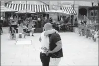  ?? AP/THE Virginian-pilot/matt EICH ?? As flash-mob dancers watch on bended knee, Michael Turner and fiancee Jamie Story embrace after she accepted his proposal last week at a plaza in Virginia Beach, Va.