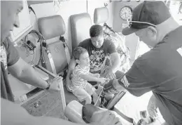  ?? TAIMY ALVAREZ/SUN SENTINEL PHOTOS ?? City of Margate Rescue 98 Firefighte­r/Paramedics Gecarri Freeman, left, and Scott Pitts show Ethan Sanchez, 7, with his dad, Adam Miranda, a blood pressure cuff Tuesday morning at Coral Gate Park.