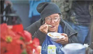  ??  ?? Dianal Tripp enjoys pumpkin pie served by volunteers with the St. Vincent de Paul Society Thursday.