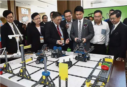  ??  ?? Interestin­g toys: Chong trying out some of the gadgets at the conference in Penang.