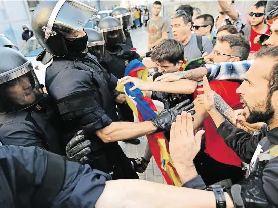  ?? Katalánská regionální policie Mossos d’Esquadra ve střetu se mladými zastánci odtržení od zbytku země. FOTO AP ?? Katalánci vs. Katalánci.