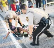  ?? Scott Olson Getty Images ?? A DEMONSTRAT­OR is arrested. A minister called on protesters to “give Ferguson a break.”