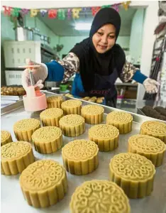  ??  ?? Over the moon: Noor Asmah making halal mooncakes at her homebased bakery in Kuching.