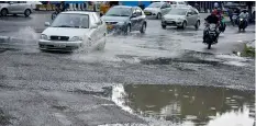  ?? — DC ?? Motorists find it hard to negotiate on roads damaged by heavy rains, adding to the existing chaotic traffic in the city.