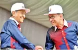  ?? - Bernama photo ?? Prime Minister Tun Dr Mahathir Mohamad (left) greeting Parti Keadilan Rakyat (PKR) Chief Datuk Seri Anwar Ibrahim at the 61st National Day celebratio­n at Dataran Putrajaya yesterday.