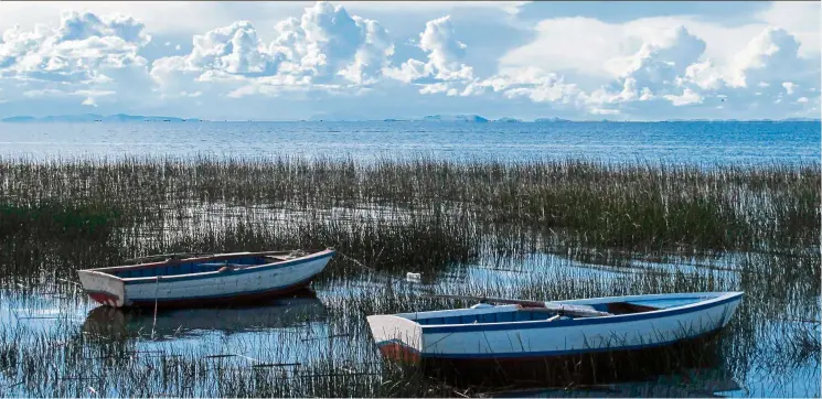  ?? — Photos: THOMAS Curwen/tns ?? residents of Luquina Chico anchor their row boats near the shore of their village which looks out upon the vast expanse of Lake titicaca, Peru.