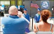  ?? SEAN D. ELLIOT/THE DAY ?? Twins Adam, left, and Thomas Riffe pose for photos after picking up their diploma covers Friday during drive-thru graduation ceremonies for Grasso Tech.