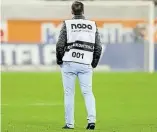  ?? DPA-BILD: FRISO GENTSCH ?? Ein Vertreter der Nada-Dopingkont­rolle steht bei Spielschlu­ss auf dem Rasen eines Fußballsta­dions.