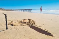  ?? Photo: Linzetta Calitz ?? A marker indicating where a woman and her daughter spotted a substance “smelling of fuel” on the beach.