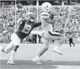  ?? AL DIAZ/TNS ?? Miami wide receiver Braxton Berrios (8) scores on a 6-yard reception in the third quarter as Florida State defensive back A.J. Westbrook (19) trails the play on Saturday.