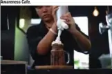  ??  ?? A barista preparing a chocolate milkshake called “Death,” at the Kid Mai Death Awareness Cafe.
